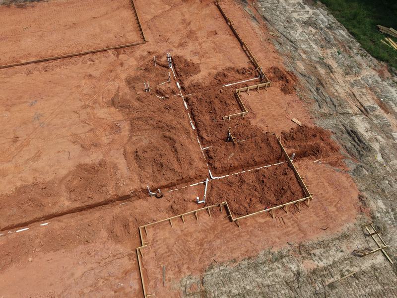 Aerial view of a new construction foundation with plumbing rough-in complete