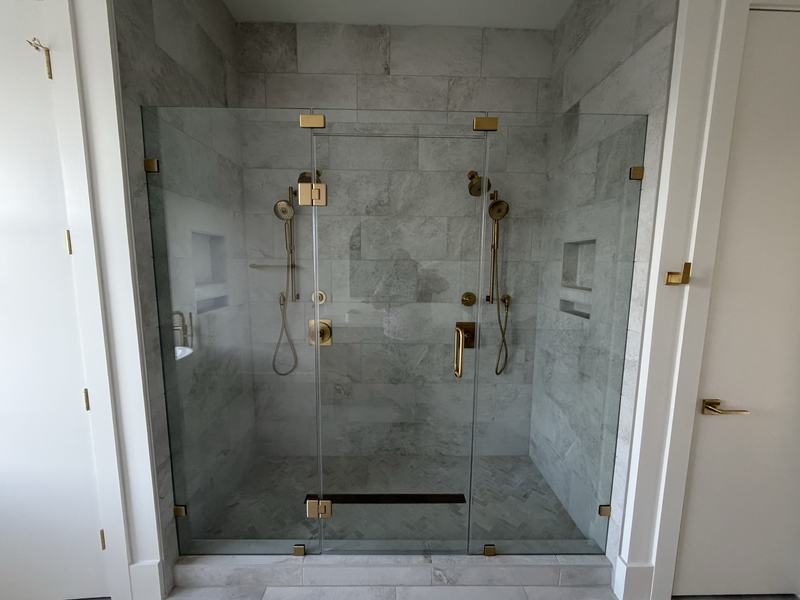Walk in glass shower with brass fixtures, plumbing completed