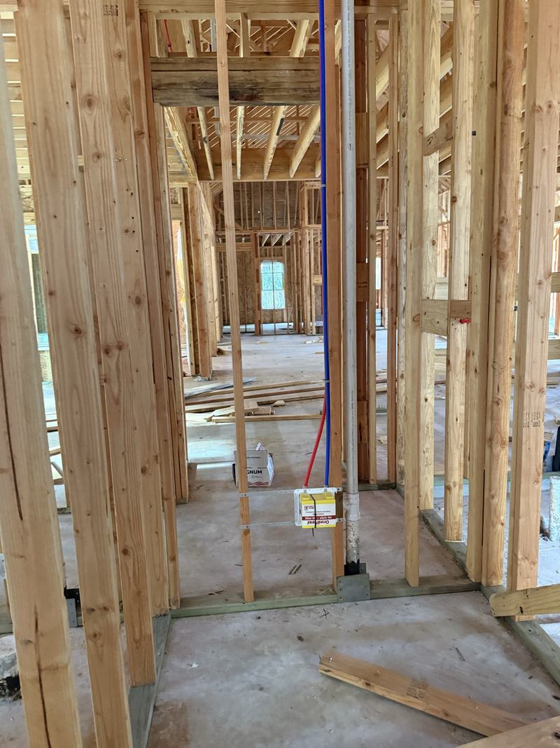 Water and drain lines run through new construction framing