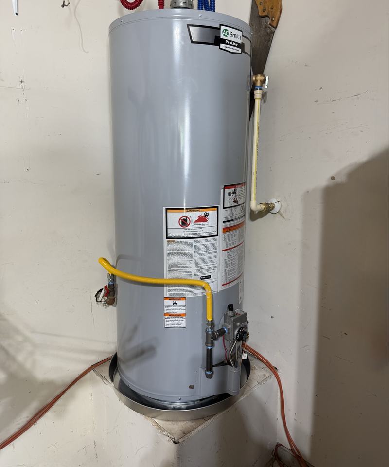 Replacement tank water heater installed with the gas connection and drain pan